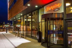 una tienda frente a un edificio por la noche en Hampton By Hilton Liverpool City Centre en Liverpool