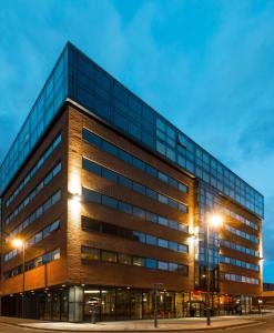 un edificio de oficinas por la noche con luces de la calle en Hampton By Hilton Liverpool City Centre en Liverpool