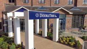 una señal azul y blanca delante de un edificio en DoubleTree by Hilton Stoke-on-Trent, United Kingdom en Stoke on Trent