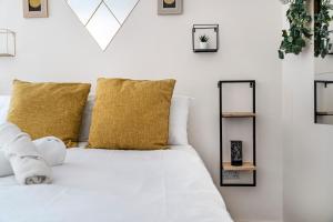 a bedroom with a white bed with yellow pillows at Leicester City Center The Boat House Building in Leicester