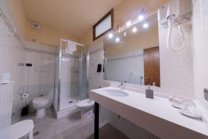 a bathroom with a sink and a toilet and a shower at Holiday Rooms Antica Badia in Volterra