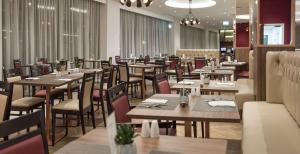 a dining room with wooden tables and chairs at Hilton Garden Inn Manchester Emirates Old Trafford in Manchester