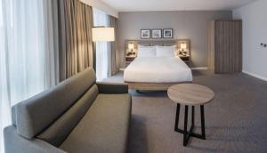 Habitación de hotel con cama y sofá en Hilton Garden Inn Manchester Emirates Old Trafford en Mánchester