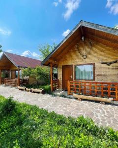 a log cabin with a porch and a patio at Sunset By The Farm in Piatra Neamţ