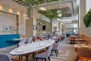 a dining room with tables and chairs at Hilton Garden Inn Stoke On Trent in Stoke on Trent