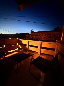 2 sillas y una mesa en el balcón por la noche en CASA Outeiro 4 en Muros