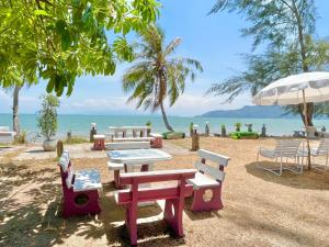 un grupo de mesas de picnic y sillas en la playa en Ava Beach Pakbara, en Ban Pak Ba Ra