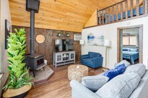 a living room with a couch and a fireplace at Quaint Loft Cabin w Hot Tub, FirePit, Deck & Grill in Hedgesville +26 photos