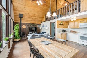 a kitchen and living room with a wooden ceiling at Quaint Cabin w Hot Tub Firepit & Deck in Hedgesville