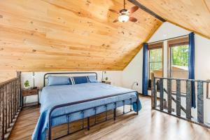 a bed in a room with a wooden ceiling at Quaint Cabin w Hot Tub Firepit & Deck in Hedgesville