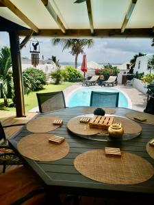 a table with straw hats and a swimming pool at VILLA PELICAN in Oyster Pond