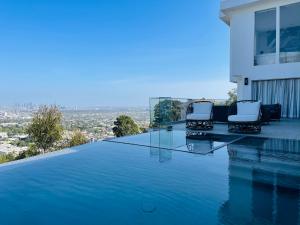 a swimming pool with two chairs on the edge of a house at Stunning View Hollywood Hills Guest House in Los Angeles
