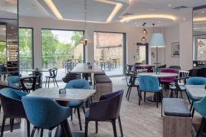 restauracja ze stołami, krzesłami i oknami w obiekcie Hampton by Hilton York Piccadilly w mieście York