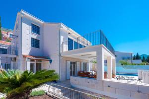 Cette grande maison blanche dispose d'un balcon. dans l'établissement Villa Mlini with private Pool and Sea view, à Mlini
