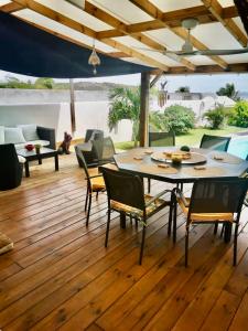 un patio con mesa y sillas en un suelo de madera en VILLA PELICAN, en Oyster Pond