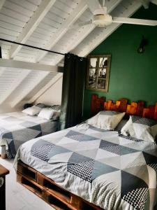 2 camas en una habitación con paredes verdes en VILLA PELICAN, en Oyster Pond