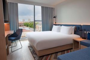 a bedroom with a large bed and a large window at Hampton by Hilton York Piccadilly in York