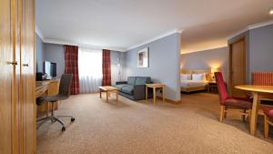 a hotel room with a bed and a living room at DoubleTree by Hilton Swindon Hotel in Swindon