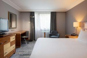a hotel room with a bed and a desk and a television at DoubleTree by Hilton Swindon Hotel in Swindon