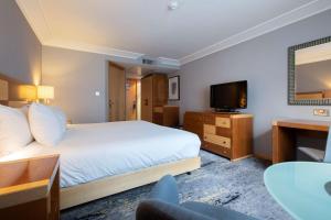 a hotel room with a bed and a flat screen tv at DoubleTree by Hilton Swindon Hotel in Swindon