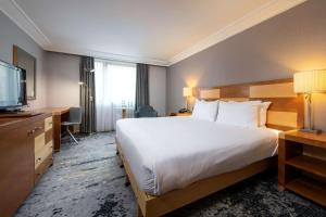 a hotel room with a large bed and a television at DoubleTree by Hilton Swindon Hotel in Swindon