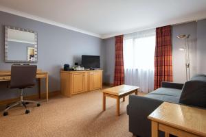 a living room with a couch and a desk at DoubleTree by Hilton Swindon Hotel in Swindon