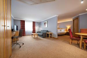 um quarto de hotel com uma cama e uma sala de estar em DoubleTree by Hilton Swindon Hotel em Swindon