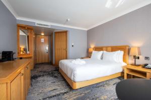 a hotel room with a bed and a television at DoubleTree by Hilton Swindon Hotel in Swindon