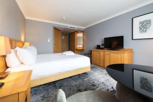 a hotel room with a bed and a television at DoubleTree by Hilton Swindon Hotel in Swindon