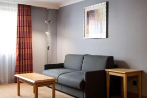 a living room with a couch and a table at DoubleTree by Hilton Swindon Hotel in Swindon