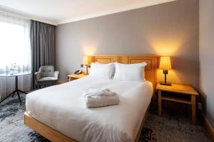 a hotel room with a large white bed with two lamps at DoubleTree by Hilton Swindon Hotel in Swindon
