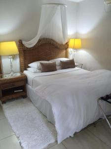 1 dormitorio con 1 cama blanca grande y 2 lámparas en Amethyst Suites (Part of Emerald Guest House), en Springs