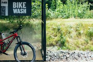 uma bicicleta estacionada ao lado de uma placa de lavagem de bicicletas em Hilton Garden Inn Snowdonia em Conwy