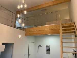 a loft bedroom with a bunk bed and a ladder at Moderne Maisonettewohnung/2 Zimmer/Küche/Bad #1 in Markt Schwaben