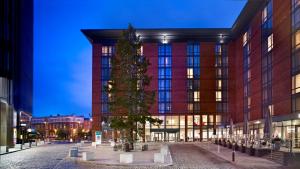 a christmas tree in front of a building at Hilton Garden Inn Birmingham Brindley Place in Birmingham