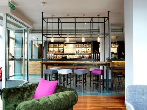 a bar with pink pillows on a green couch at Hilton Garden Inn Birmingham Brindley Place in Birmingham