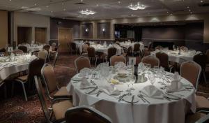 - une salle de banquet avec des tables, des chaises et du linge de maison blanc dans l'établissement DoubleTree by Hilton Bristol City Centre, à Bristol