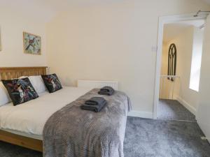 Un dormitorio con una cama con una manta. en 5 Tai Isa, en Barmouth