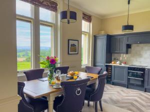 a kitchen with a wooden table with chairs and a dining room at Geltsdale East Wing sleeps 6 with River Eden views near Carlisle & Ullswater in Wetheral
