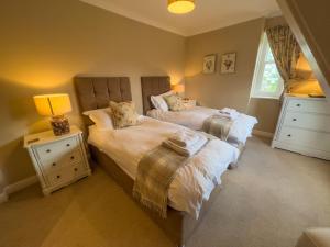 a bedroom with two beds and two night stands at Geltsdale East Wing sleeps 6 with River Eden views near Carlisle & Ullswater in Wetheral