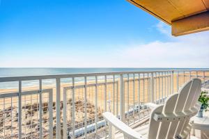 a balcony with two chairs and the beach at Dunes Suites Oceanfront in Ocean City
