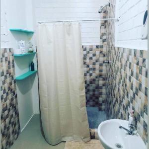 łazienka z zasłoną prysznicową i umywalką w obiekcie Departamento familiar w mieście Lobitos