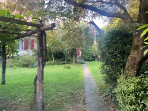 a path through a yard with trees and a house at Cozy apartment in the green in Locarno
