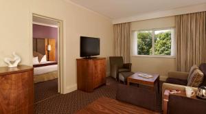 a hotel room with a television and a living room at DoubleTree by Hilton Sheffield Park in Sheffield