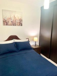 a bedroom with a blue bed with a blue blanket at Hab Nawi con Aire Acondicionado in Cali