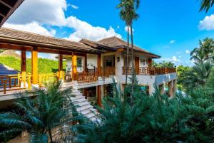 dom z palmami przed nim w obiekcie Sunny Vacation Villa No 71 w mieście San Rafael del Yuma