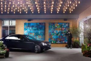 a man standing next to a car in front of a building at Hilton London Bankside in London