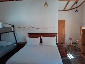 1 dormitorio con 1 cama con sábanas blancas en Hotel-Camping Takha Takha en San Pedro de Atacama