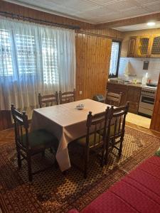 mesa de comedor con sillas y cocina en Apartment Bella 2 en Požega