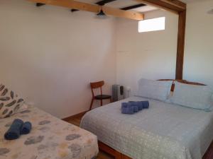 1 dormitorio con 2 camas y 1 silla en Hotel-Camping Takha Takha, en San Pedro de Atacama